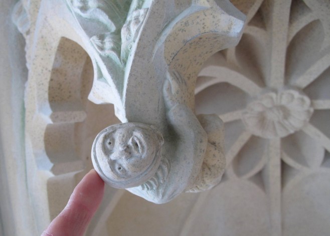 A tiny figure clings on to the tracery