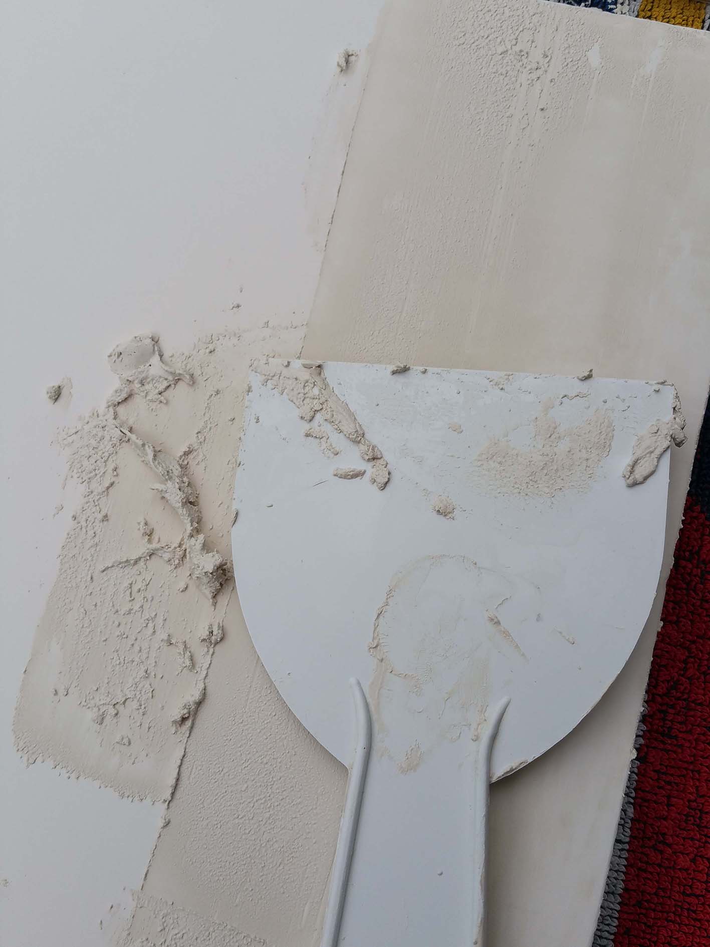 using a spatula to apply the gesso in thin layers